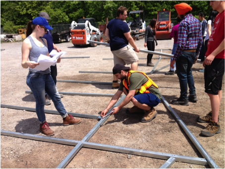 Learning basic greenhouse construction techniques in the Dominican Republic, students assemble a gable end.